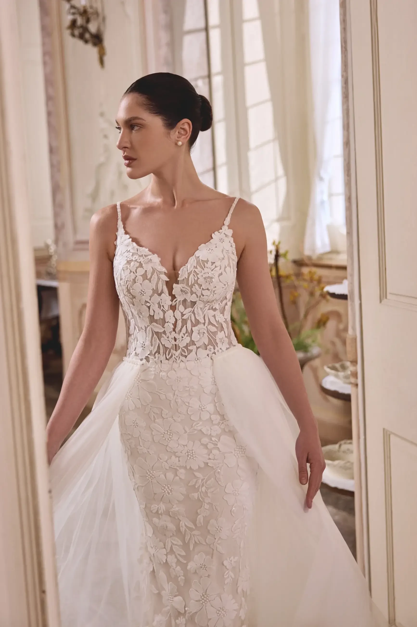 model is wearing a spaghetti strap lace wedding dress